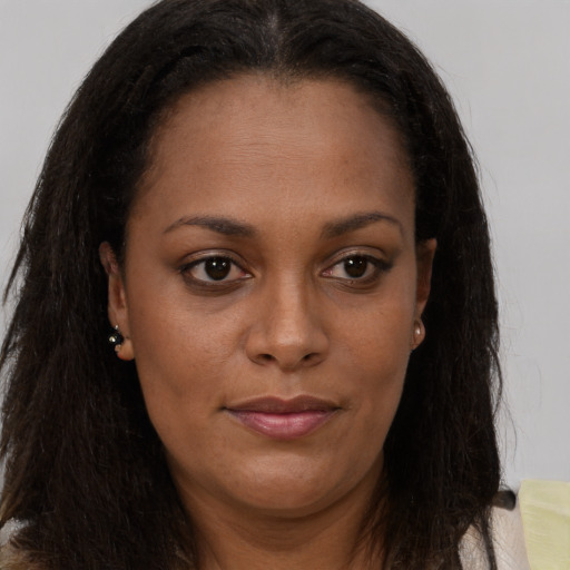 Joyful black young-adult female with long  brown hair and brown eyes