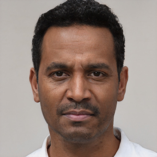 Neutral latino adult male with short  black hair and brown eyes