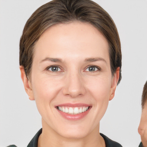 Joyful white adult female with short  brown hair and grey eyes