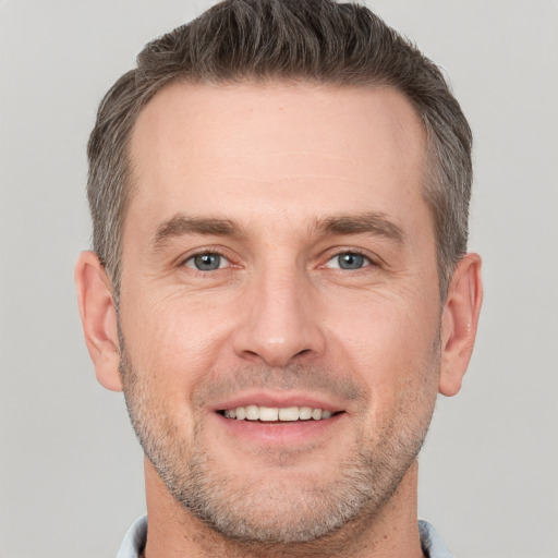 Joyful white adult male with short  brown hair and grey eyes