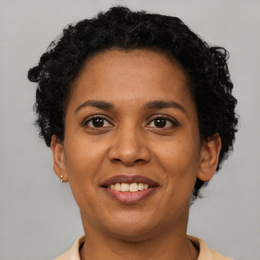 Joyful black adult female with short  brown hair and brown eyes