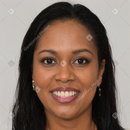 Joyful black young-adult female with long  brown hair and brown eyes