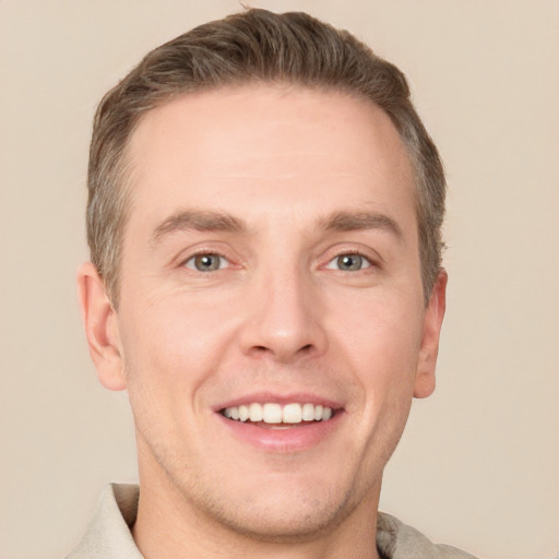 Joyful white adult male with short  brown hair and grey eyes