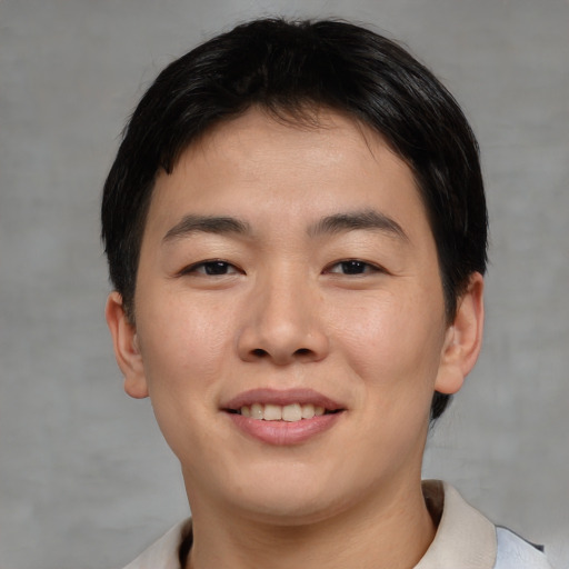 Joyful asian young-adult male with short  brown hair and brown eyes