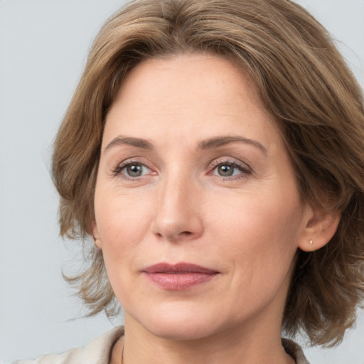 Joyful white adult female with medium  brown hair and brown eyes