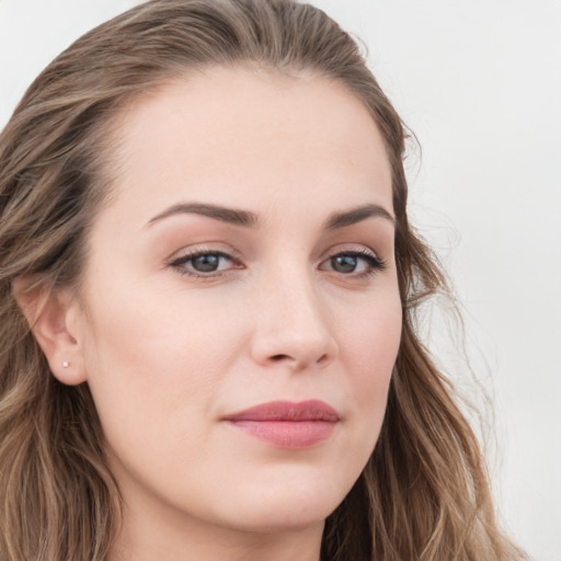 Joyful white young-adult female with long  brown hair and blue eyes