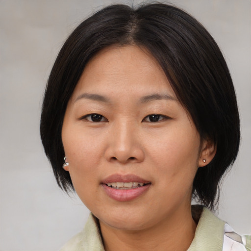 Joyful asian adult female with medium  brown hair and brown eyes