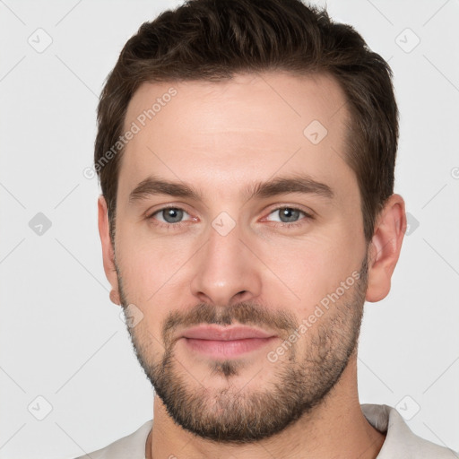 Joyful white young-adult male with short  brown hair and grey eyes