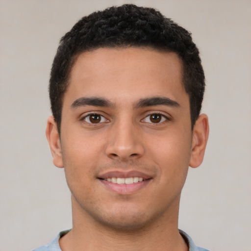 Joyful latino young-adult male with short  brown hair and brown eyes