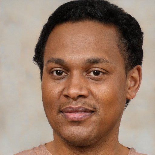 Joyful black young-adult male with short  black hair and brown eyes
