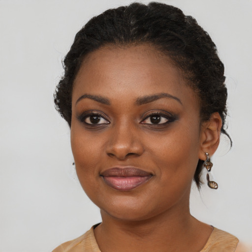 Joyful black young-adult female with long  brown hair and brown eyes