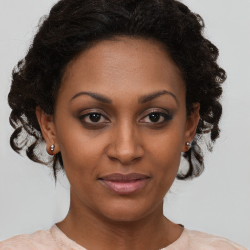 Joyful black young-adult female with medium  brown hair and brown eyes