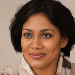 Joyful black adult female with medium  brown hair and brown eyes