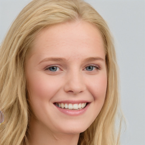 Joyful white young-adult female with long  blond hair and blue eyes