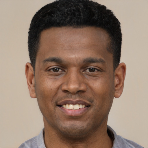 Joyful black young-adult male with short  black hair and brown eyes