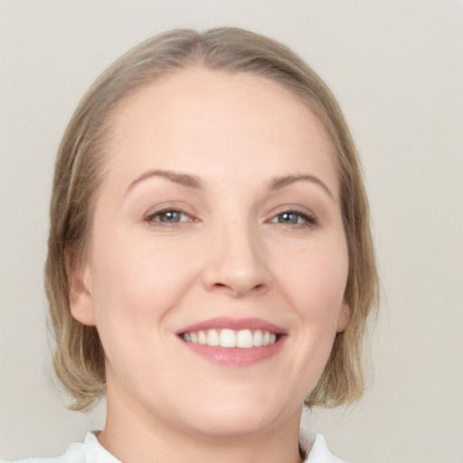 Joyful white young-adult female with medium  brown hair and blue eyes