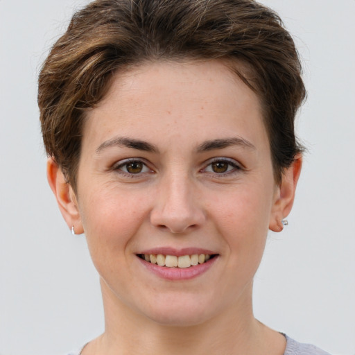 Joyful white young-adult female with short  brown hair and grey eyes