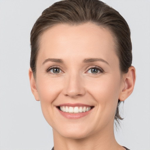 Joyful white young-adult female with medium  brown hair and grey eyes