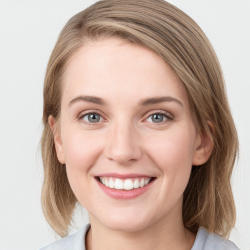 Joyful white young-adult female with medium  brown hair and green eyes