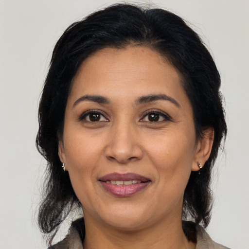 Joyful latino adult female with medium  brown hair and brown eyes