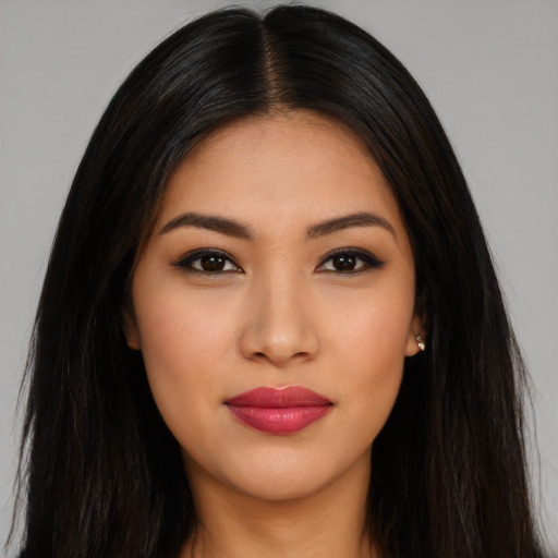 Joyful latino young-adult female with long  brown hair and brown eyes