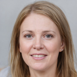 Joyful white adult female with long  brown hair and grey eyes