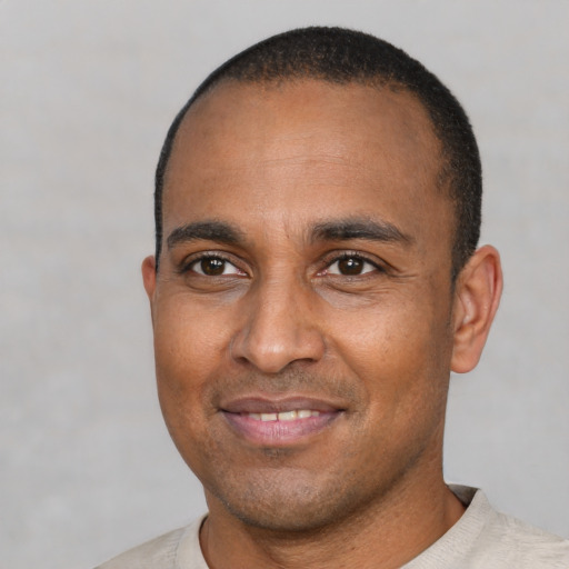 Joyful latino adult male with short  brown hair and brown eyes