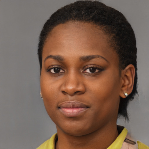 Joyful black young-adult female with short  black hair and brown eyes