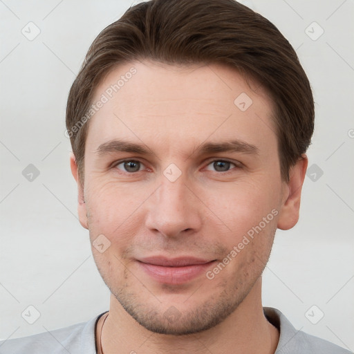 Joyful white young-adult male with short  brown hair and grey eyes