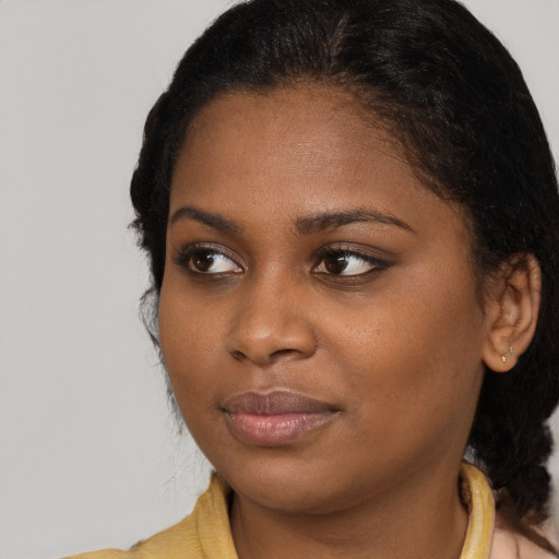 Joyful black young-adult female with medium  brown hair and brown eyes