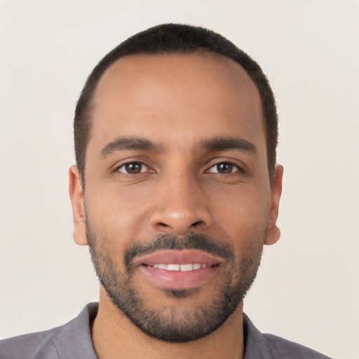 Joyful latino young-adult male with short  brown hair and brown eyes