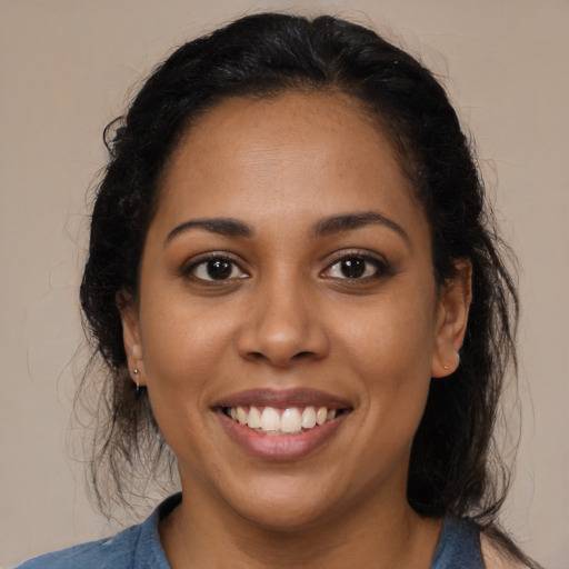 Joyful latino young-adult female with long  brown hair and brown eyes
