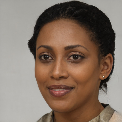 Joyful black young-adult female with short  black hair and brown eyes