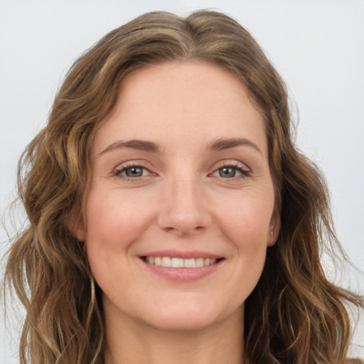 Joyful white young-adult female with long  brown hair and green eyes