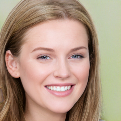 Joyful white young-adult female with long  brown hair and blue eyes