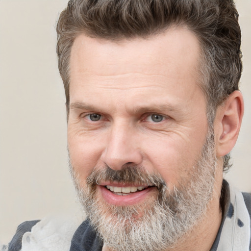 Joyful white adult male with short  brown hair and grey eyes