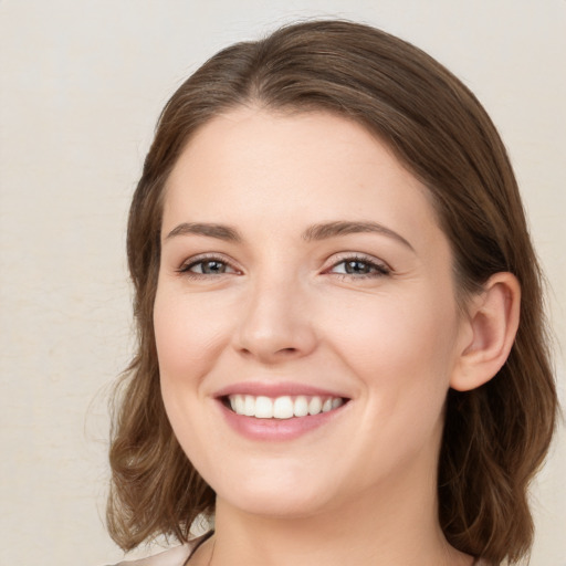 Joyful white young-adult female with medium  brown hair and green eyes