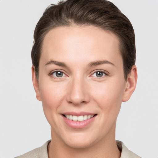 Joyful white young-adult female with short  brown hair and grey eyes