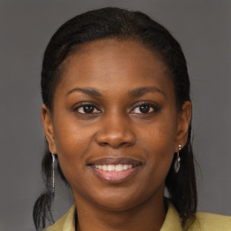 Joyful black young-adult female with long  brown hair and brown eyes