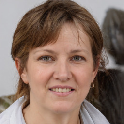 Joyful white adult female with medium  brown hair and grey eyes