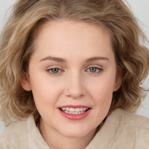 Joyful white young-adult female with medium  brown hair and blue eyes