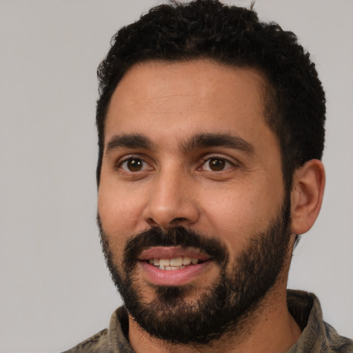 Joyful latino young-adult male with short  black hair and brown eyes