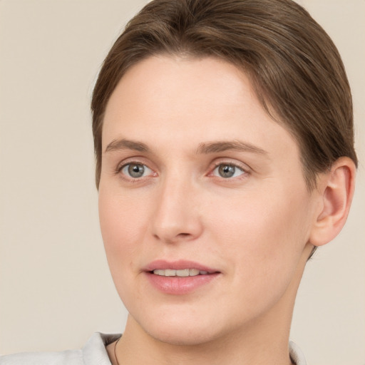 Joyful white young-adult female with short  brown hair and grey eyes