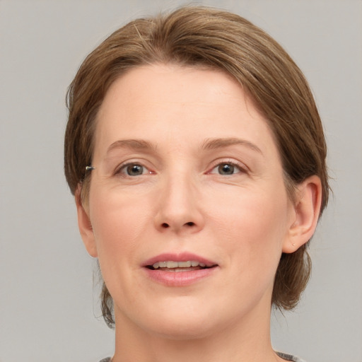 Joyful white adult female with medium  brown hair and grey eyes