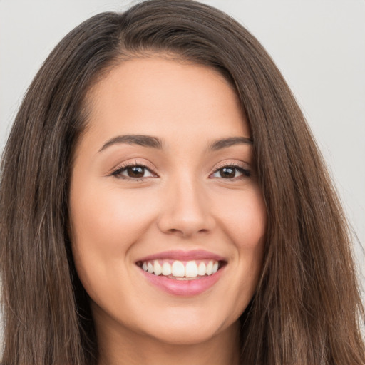 Joyful white young-adult female with long  brown hair and brown eyes