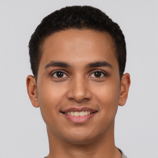 Joyful latino young-adult male with short  brown hair and brown eyes