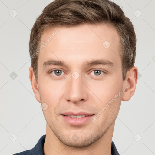 Joyful white young-adult male with short  brown hair and grey eyes