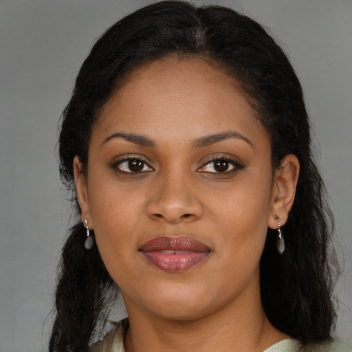 Joyful black young-adult female with long  brown hair and brown eyes