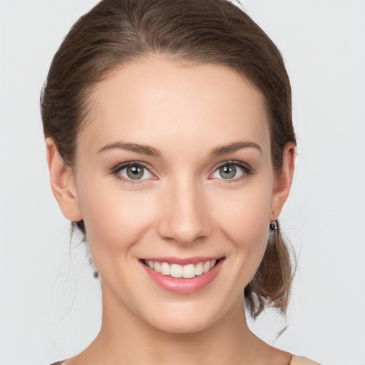 Joyful white young-adult female with medium  brown hair and grey eyes