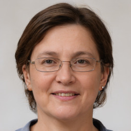 Joyful white adult female with medium  brown hair and grey eyes